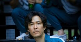 Seong Gi-hun wearing tracksuit 456, sitting on steps, holding a drink, showcasing intense expressions from Squid Game.