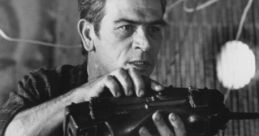 Chip Hazard, portrayed by Tommy Lee Jones, holds a weapon, showcasing intensity and readiness for action in this scene.