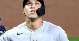 Aaron Judge in a New York Yankees uniform, looking up, ready for his next move during a game.