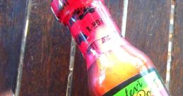 Levi Roots' Reggae Reggae hot sauce bottle on a wooden surface, showcasing vibrant packaging and Caribbean flair.