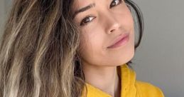 Valkyrae smiles in a cozy yellow hoodie, showcasing her signature style and radiant personality.