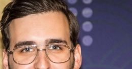 Young man with glasses and a stylish burgundy jacket, smiling against a colorful backdrop, representing modern elegance.
