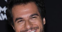 Smiling man in a stylish white jacket, showcasing charm and confidence at a glamorous event. Perfect for Amir fan pages.