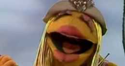 Janice sings passionately while playing guitar, showcasing her vibrant personality and iconic Muppet charm.