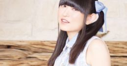 Yukari Tamura in a stylish light blue dress, showcasing her vibrant personality and iconic voice talent in a serene setting.