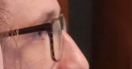 Close-up profile of a man with glasses, deep in thought, highlighting unique facial features and expressions.