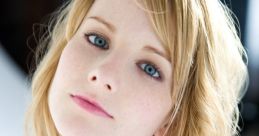 Melissa Rauch showcasing her natural beauty with long, wavy blonde hair and striking blue eyes, radiating charm and elegance.