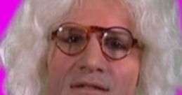 Brian Badonde with curly white hair, glasses, and vibrant clothing, set against a bold pink backdrop.