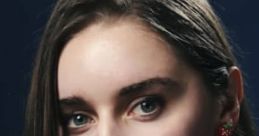 Close-up of a young woman with long hair, wearing unique earrings, showcasing vibrant personality and charm.