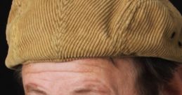 Brian Cummings with a textured tan cap, sporting a beard and a friendly expression against a dark background.