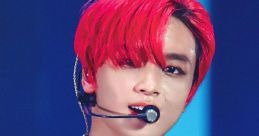 Cool Kid performing with vibrant red hair, captivating audience with charisma and unique style on stage.