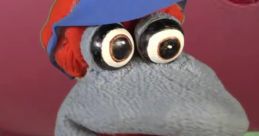 Liz from "Liz & Friends" TTS character, showcasing a playful puppet with big eyes and a colorful cap, ready for fun.