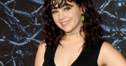 Mary Mouser showcases her chic style in a trendy black crop top and colorful patterned skirt at a recent event.