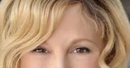 Smiling portrait of Julie Aigner-Clark, founder of Baby Einstein, showcasing her blonde, wavy hair and friendly expression.