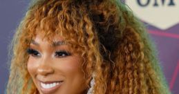 Tiera Kennedy showcases her stunning hairstyle and radiant smile at a recent CMT event, exuding confidence and style.