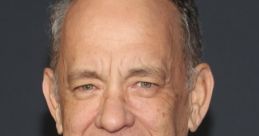 Tom Hanks smiling confidently at a red carpet event, showcasing his classic style in a black suit and tie.