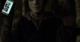 The Man from Hush 2016 holding a smartphone, wearing a mask in a dark forest setting, evoking suspenseful thriller vibes.