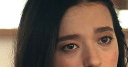 Amber Freeman, portrayed by Mikey Madison in Scream V, gazes thoughtfully with dark hair and a stylish outfit.
