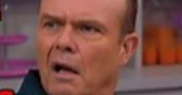 Red Forman shows a shocked expression while wearing a blue shirt, capturing his iconic character's comedic moments.