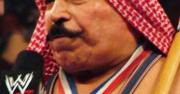 The Iron Sheik wearing a championship medal, holding a microphone, highlights his iconic wrestling persona in WWE.