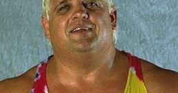 Dusty Rhodes smiling in a colorful tie-dye tank top, showcasing his iconic wrestling persona and charisma.