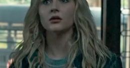 Lexy Cross appears surprised in a cozy, layered outfit, highlighting her expressive features and wavy hair.