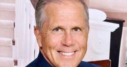 Cheerful Scotty Knight smiling while promoting “Walkin' on Sunshine,” dressed in a blue shirt and tie.