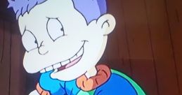 Tommy from "All Grown Up!" smiles while cleaning, showcasing his playful spirit and iconic purple hair.