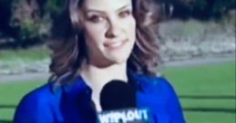 Jill Wagner hosting Wipeout, smiling with a microphone, wearing a blue shirt, set in a vibrant outdoor location.