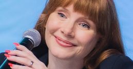 Bryce Dallas Howard speaking at a panel, showcasing her signature red hair and vibrant manicure, exuding charisma.
