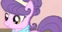 Suri Polomare, a pink pony from My Little Pony, featuring a stylish scarf and vibrant curls, embodies fashion and creativity.