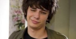 Rodrick Heffley showcasing a casual style, confident expression, and unique graphic tee in a home setting.