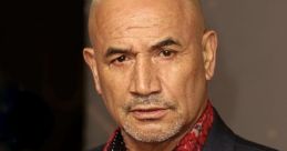 Temuera Morrison in a stylish outfit, showcasing his signature look with a confident expression at a red carpet event.