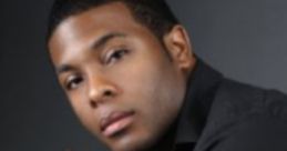 Kel Mitchell poses stylishly in a black shirt, showcasing a confident look reminiscent of his 1999 fame.