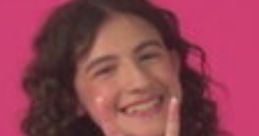 Smiling kid making the "I love you" sign in ASL, wearing a blue jacket against a vibrant pink background.