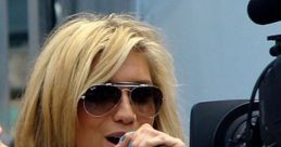 Kelly Sebert performing passionately, wearing sunglasses and a sparkling outfit, engaging with an audience.