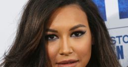 Naya Rivera with long, wavy hair and striking makeup, exuding confidence on the red carpet at a film premiere.