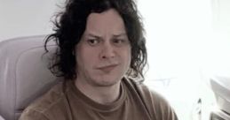 Jack White relaxing on an airplane, focused on a book, showcasing his unique style and thoughtful expression.