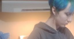 Person with teal hair preparing food in a cozy kitchen, showcasing a casual and creative home atmosphere.