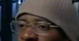 Man speaking passionately, wearing a beanie and glasses, showcasing intensity in a reflective setting.