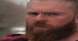 Muscular man with a thick beard, wearing a flannel shirt and holding an orange tool, embodies the spirit of the Greenboro Bear.