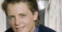 Michael J. Fox as Alex P. Keaton, smiling in a navy sweater and tie, capturing the charm of his Family Ties character.