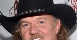 Trace Adkins smiles confidently in a cowboy hat, showcasing his signature style at a public event.