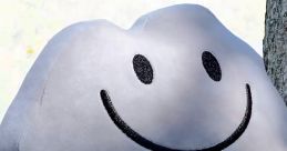 Smiling rock plush toy hanging between two trees, inspired by Rocky from BFB, showcasing a cheerful expression.