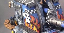Basilisk tank model from Warhammer 40,000, featuring striking flames and vibrant artwork on a detailed miniature design.