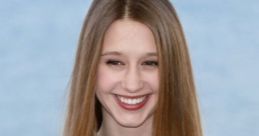 Taissa Farmiga smiles brightly, showcasing her long hair and elegant style against a scenic background.