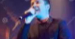 Rick Astley performing live on stage, passionately singing with a microphone under vibrant stage lights.