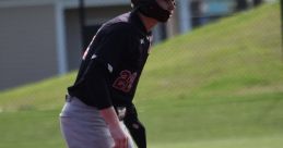 Dean Baseball 2026 player on the field, poised and ready in black uniform, showcasing athleticism and team spirit.