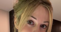 Bri Blossom showcases a fresh and natural look with her stylish bun and soft makeup, radiating confidence and beauty.