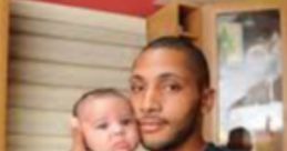 Father holding a baby in a cozy kitchen, capturing a tender moment of care and connection between parent and child.